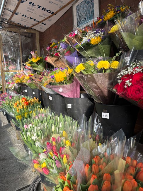 A variety of fresh floral arrangements displayed for flower delivery at Greenwich Florist, featuring colorful bouquets of tulips, roses, and mixed seasonal flowers wrapped in paper and cellophane. The
