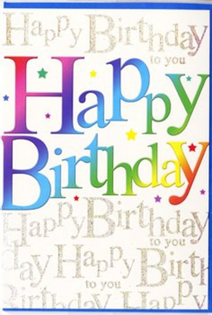This photograph shows a modern, vibrant birthday card whose design captures the carefree spirit of a colourful celebration. At the centre of the composition, the words Happy Birthday are written in oversized, rounded letters that stretch across most of the card's width. Each letter flows seamlessly into the next through a rich rainbow gradient, sliding from bold crimson and raspberry tones into plum, cobalt, teal, fresh grass green, and finally warm citrus yellow. The colours feel layered and soft-edged, blending the way a local Greenwich florist might blur shades between gerberas and roses when creating a joyful birthday bouquet. Behind this statement text lies a more intricate backdrop: the phrase Happy Birthday to you repeats in fine, looping gold script, line after line, forming a delicate pattern that covers the entire surface. The metallic ink gives the impression of glitter without appearing heavy, catching the light subtly, like the glimmer on the River Thames seen from the edge of Greenwich Park on a bright afternoon. Tiny, scattered star-like dots and specks of pastel colour are interwoven between the foreground letters and the script, adding a touch of playful confetti and suggesting movement, as though the design were mid-celebration. The card's finish appears smooth and lightly reflective, making the colours look richer and more saturated. Overall, the mood is upbeat and affectionate, perfect for a birthday greeting that feels more like a moment of shared joy than a simple message, the kind of card you might slip into a bouquet before delivering it to a birthday gathering near Maze Hill or down by the Cutty Sark.