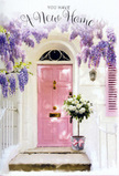 This image captures a serenely romantic Greenwich entrance, the sort of doorway you might discover on a peaceful walk between the river and Greenwich Park. A soft pink front door, painted in a velvety, chalk-like finish, forms the gentle focal point, its panels subtly highlighted by shafts of warm daylight. The surrounding wall is whitewashed and slightly textured, allowing shadows to dance gently as light filters through generous garlands of wisteria overhead. The wisteria falls in tumbling streams of lavender and dusty purple, clusters of blossoms overlapping like layers of silk and creating a fragrant canopy that frames the door. To one side, a pale blush shutter quietly echoes the pink of the door, tying the scene together with an artist's sense of balance. At the base of the doorway, resting squarely on the step, sits a metal florist's bucket in soft, weathered grey. From it spills an abundant arrangement of creamy white roses, each bloom full, round, and velvety, nestled closely together. Threads of fresh green foliage wind through the bouquet, adding contrast and a hint of garden wildness, as though the flowers were gathered from a hidden courtyard just off Greenwich Market. A delicate pink satin ribbon encircles the bucket, finished in a simple bow whose tails trail lightly against the stone. The atmosphere is intimate and hopeful, perfect for a housewarming or new home celebration, as if someone has just received a same-day delivery from their favourite Greenwich florist to mark the first step over a brand-new threshold filled with love, comfort, and promise.